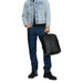 Light blue denim jacket over dark jeans with a black Calvin Klein bag in hand