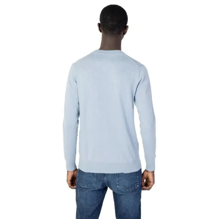 Light blue long-sleeved pullover on model from behind in Calvin Klein Jeans knitwear