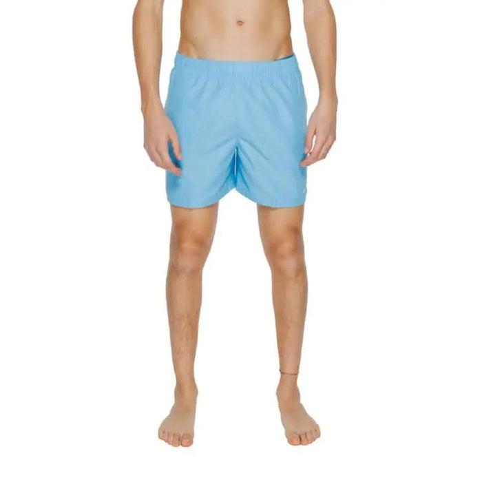 Light blue Nike Swim swim shorts worn by a model showcasing men’s swimwear