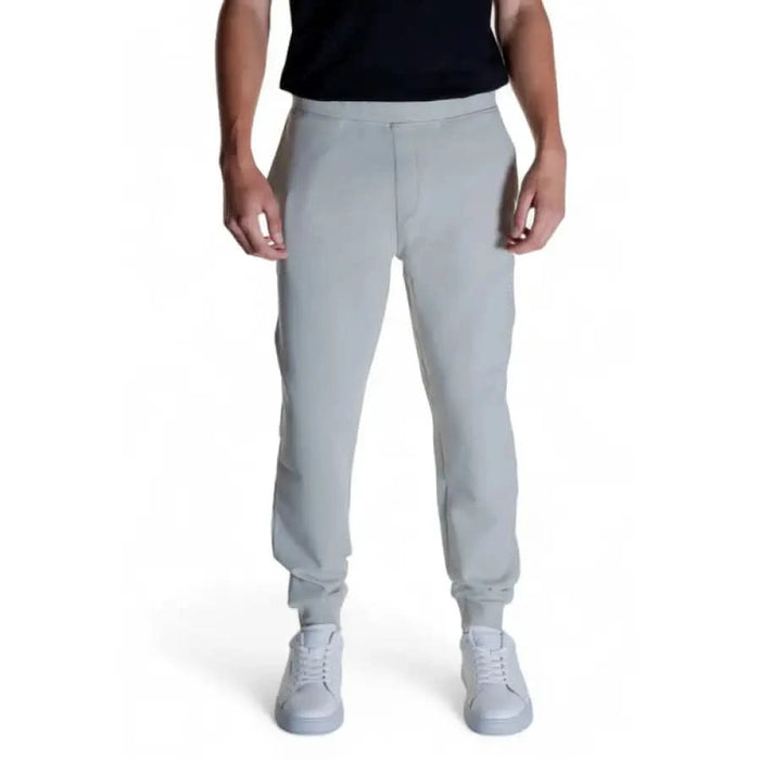 Calvin Klein Men Trousers: Light gray sweatpants with elastic cuffs at the ankles