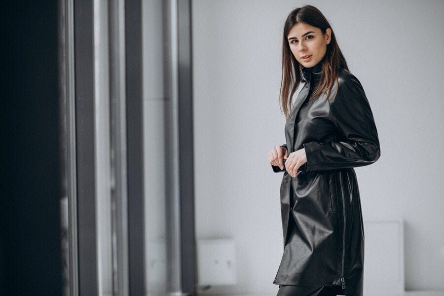 Long black leather coat styled with a turtleneck sweater for a chic outfit.