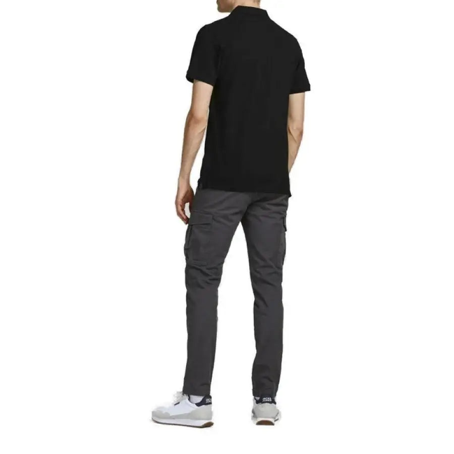 A man in a black t-shirt and grey pants modeling Jack & Jones Men Polo
