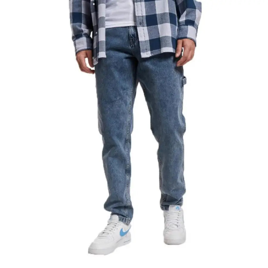 Man in blue plaid shirt and Karl Kani Men Jeans, showcasing urban fashion style