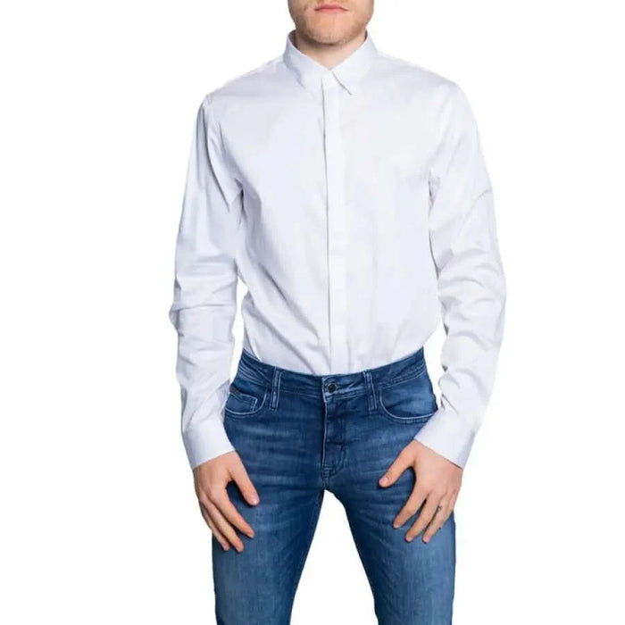 Man wearing Armani Exchange crisp white button-down shirt and blue jeans