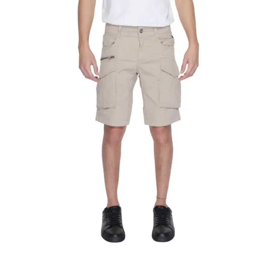 Man wearing Replay Men Shorts and white T-shirt; casual summer outfit, outdoor setting