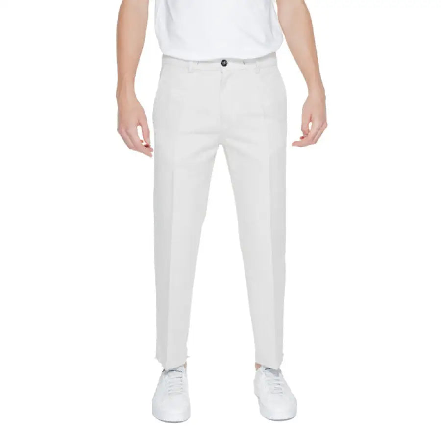 Man in white pants and t-shirt showcasing urban style from Liu Jo Men Trousers collection