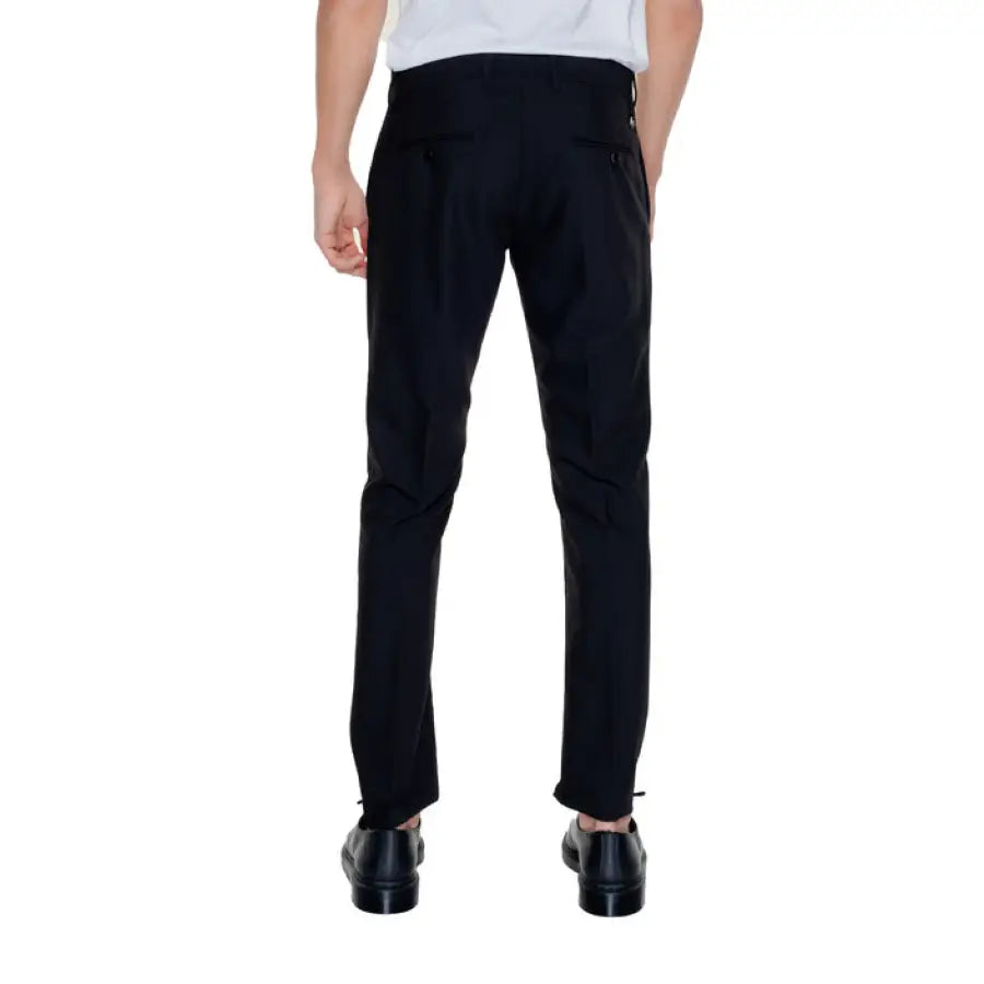 Man in white shirt and black Antony Morato trousers modeling urban style