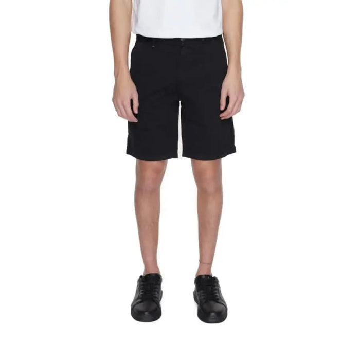 Man in white shirt and black Boss Men Shorts showcasing urban city style fashion