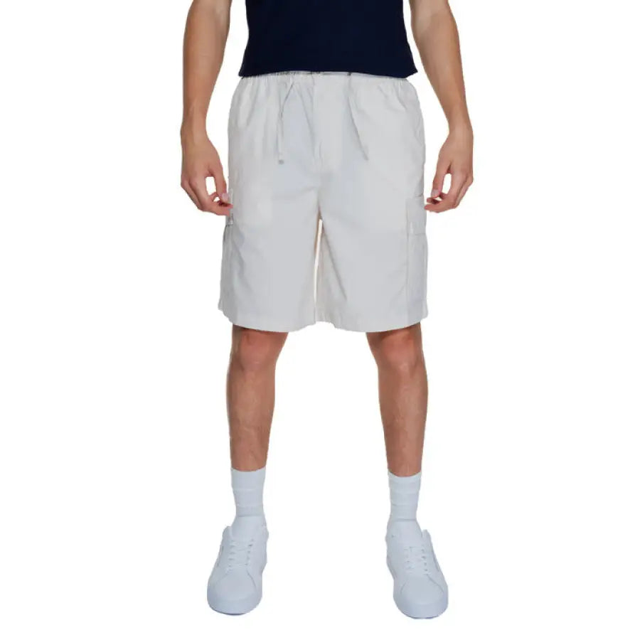 A man wearing white shorts and a black t-shirt from Jack & Jones Men Shorts collection