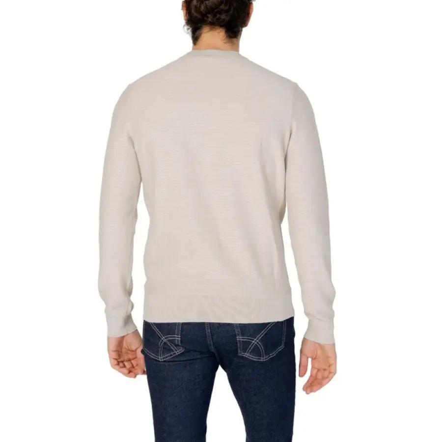 Man wearing white sweater and jeans from Boss Men Knitwear collection