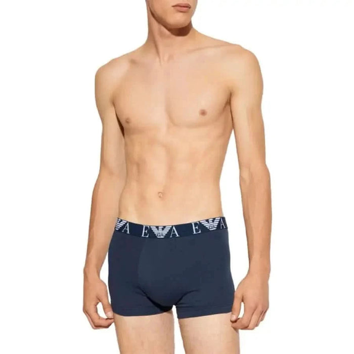 Navy blue boxer briefs with branded waistband on shirtless male torso by Emporio Armani