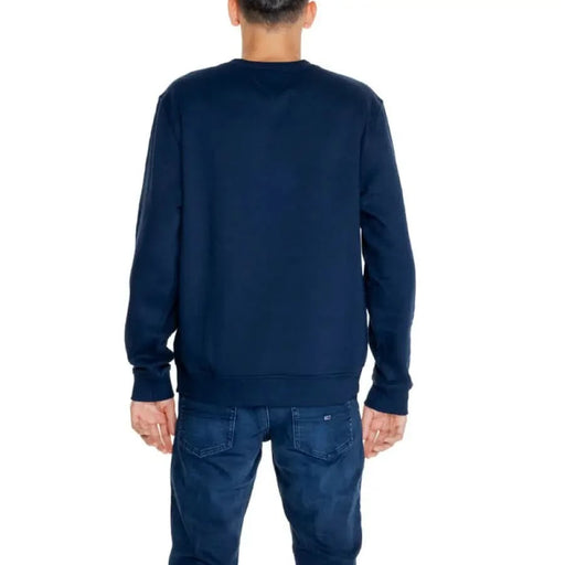 Man wearing Navy blue crewneck sweatshirt by Tommy Hilfiger viewed from the back