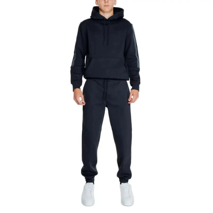 Calvin Klein Jeans navy blue sweatsuit with hooded sweatshirt, sweatpants, and white sneakers