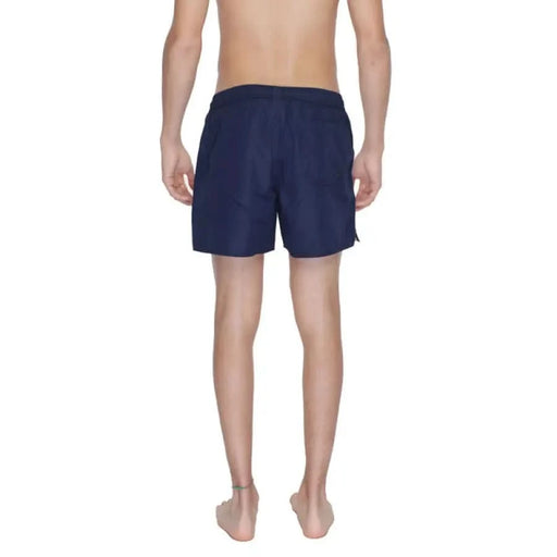 A person wearing Emporio Armani navy blue swim shorts or board shorts