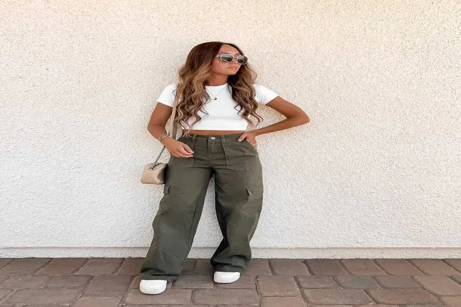 Olive green cargo pants with a white crop top and sneakers for a trendy outfit.