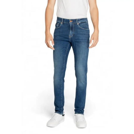 Pair of blue denim Gas Men Jeans worn with a white shirt and sneakers