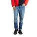 Blue denim jeans paired with a red jacket and black shoes from Tommy Hilfiger