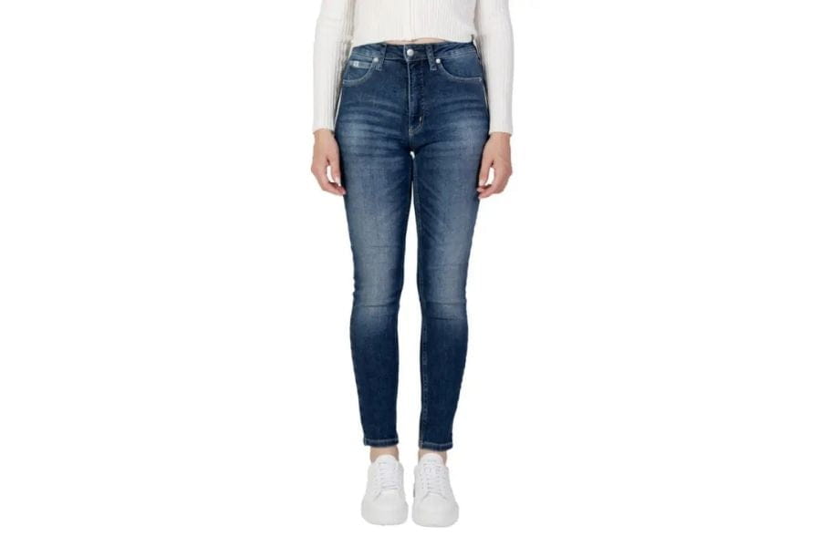 Pair of blue skinny jeans paired with white sneakers and a white top in a capsule wardrobe.