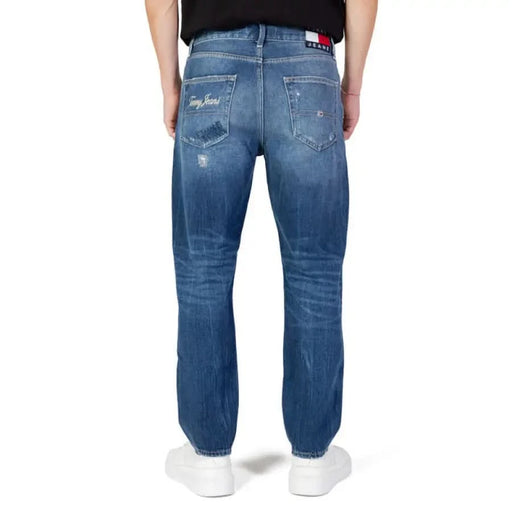 Distressed blue Tommy Hilfiger jeans featuring a faded and worn appearance