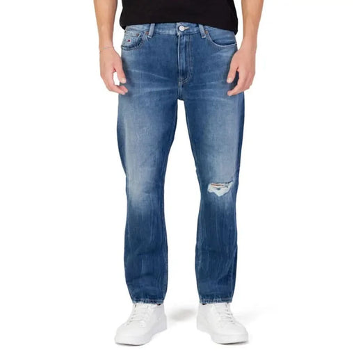 Distressed blue Tommy Hilfiger jeans featuring a rip in one knee for men