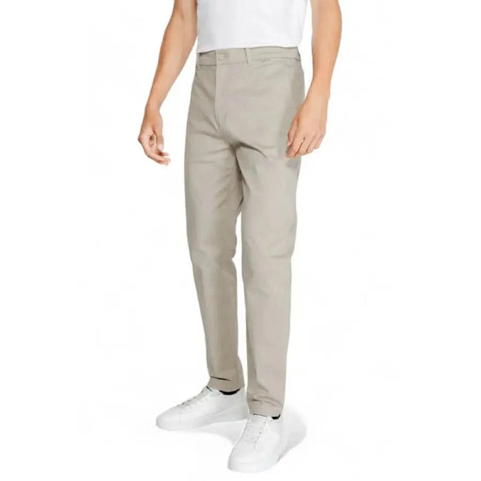 Calvin Klein Men Trousers in light gray paired with white sneakers and shirt