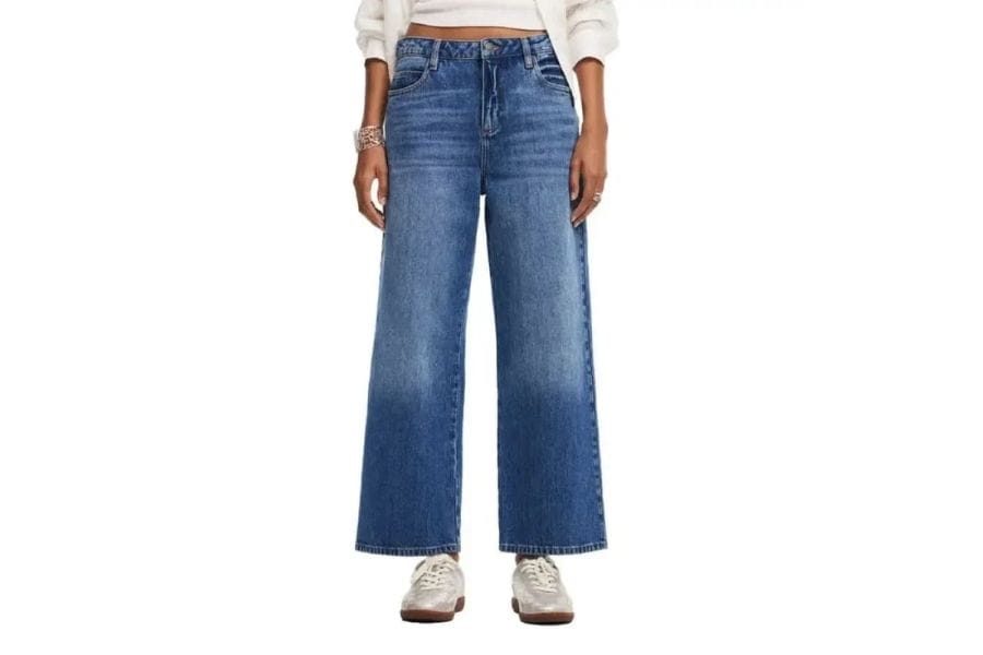 Wide-leg blue jeans worn by a person, featured in a capsule wardrobe article.