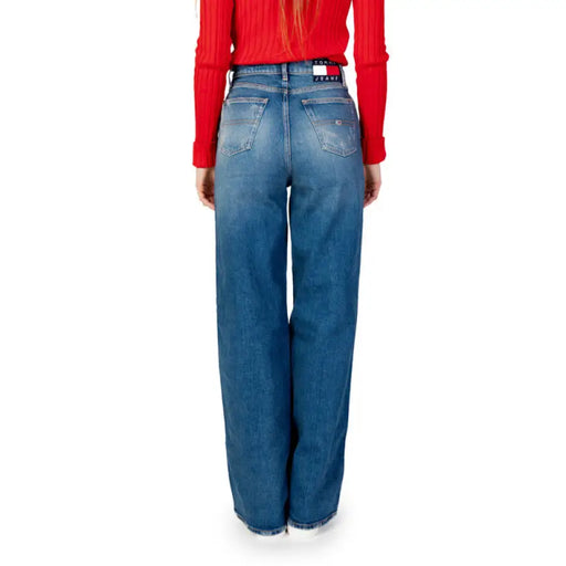 Pair of wide-leg blue jeans styled with a red top, featured in Tommy Hilfiger collection