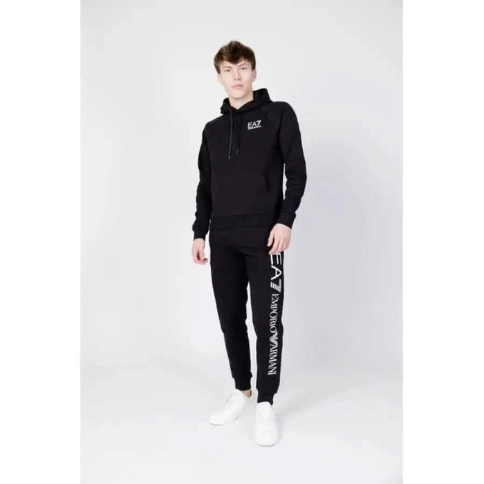 Person in black hooded sweatsuit and white sneakers from Ea7 Men Sweatshirts collection