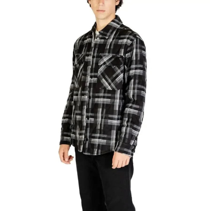 Plaid flannel shirt in black and gray pattern worn by individual from Gianni Lupo