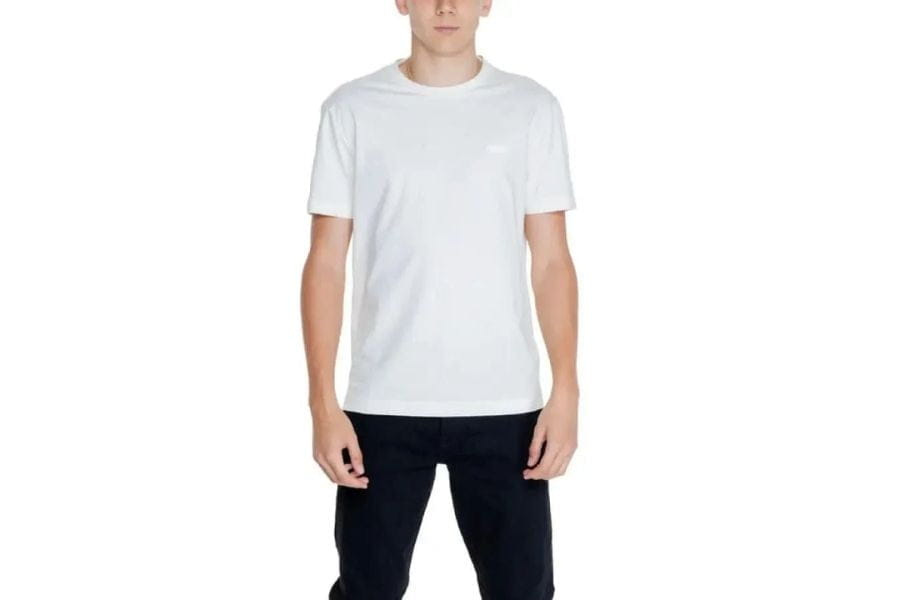 Plain white crew neck t-shirt worn by a person in men’s capsule wardrobe guide article.