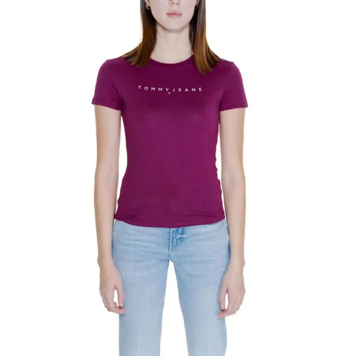 Woman wearing a Purple Tommy Jeans t-shirt with light blue jeans from Tommy Hilfiger