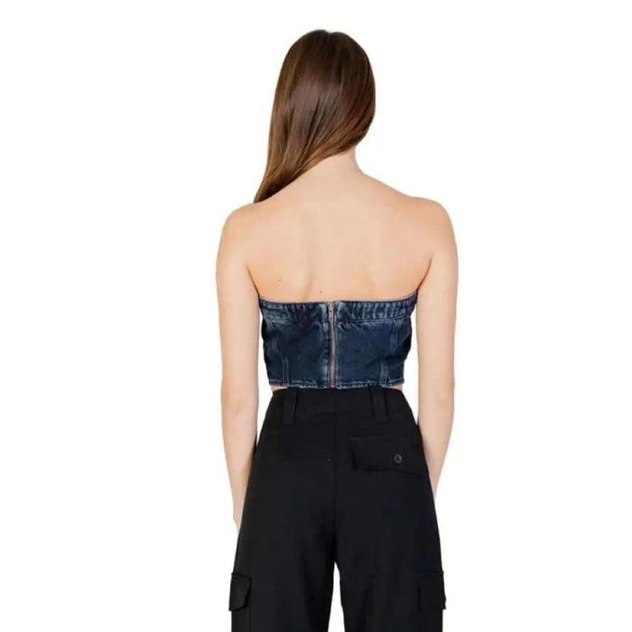 Strapless denim top and black high-waisted pants from the back, Calvin Klein Jeans