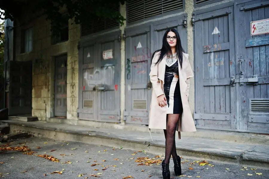 Stylish outfit with beige trench coat, black dress, platform boots, and sheer tights.