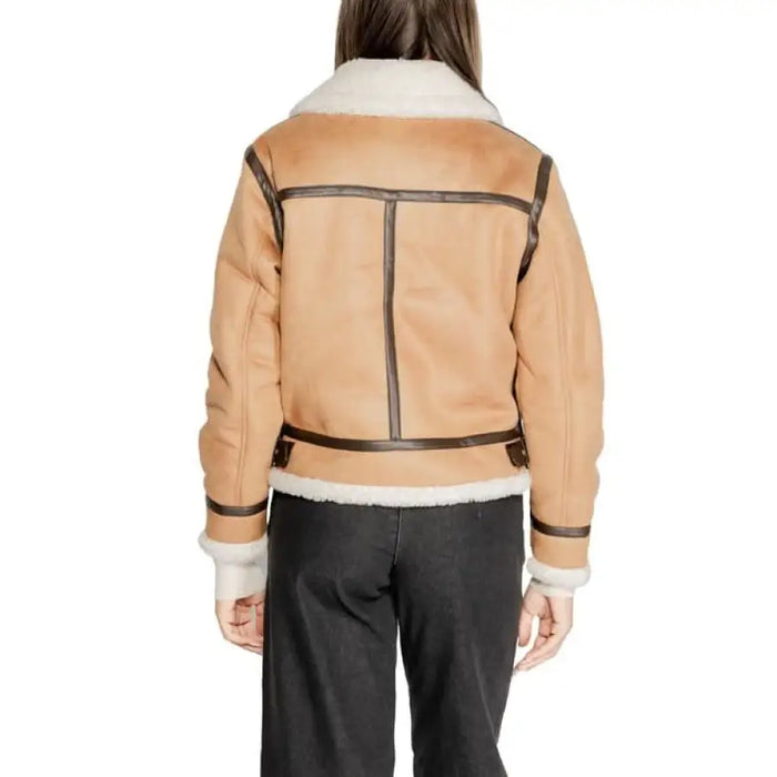 Tan shearling-lined leather jacket with dark trim displayed from the back by Clerã©