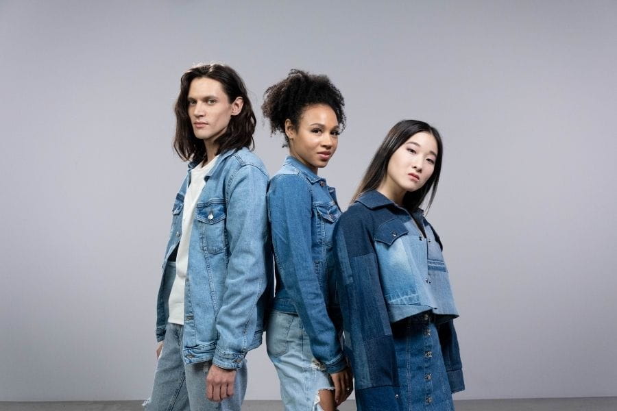 Three diverse young women in denim jackets showcasing retro style fashion.