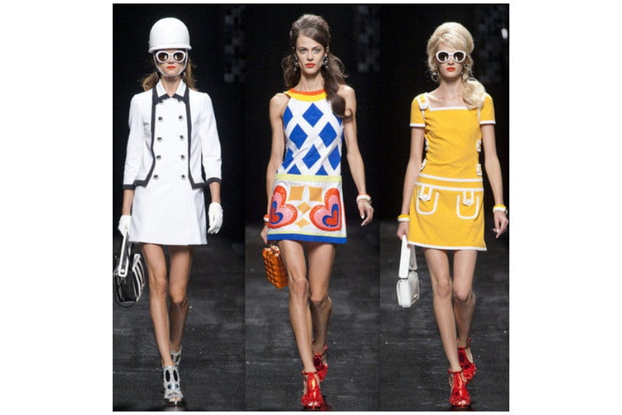 Three women showcasing vibrant retro fashion trends on a runway in stylish outfits.