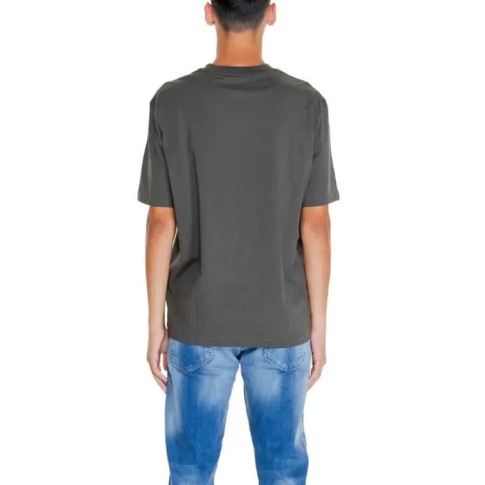 Back view of a person in a dark gray round neck Armani Exchange men t-shirt and blue jeans