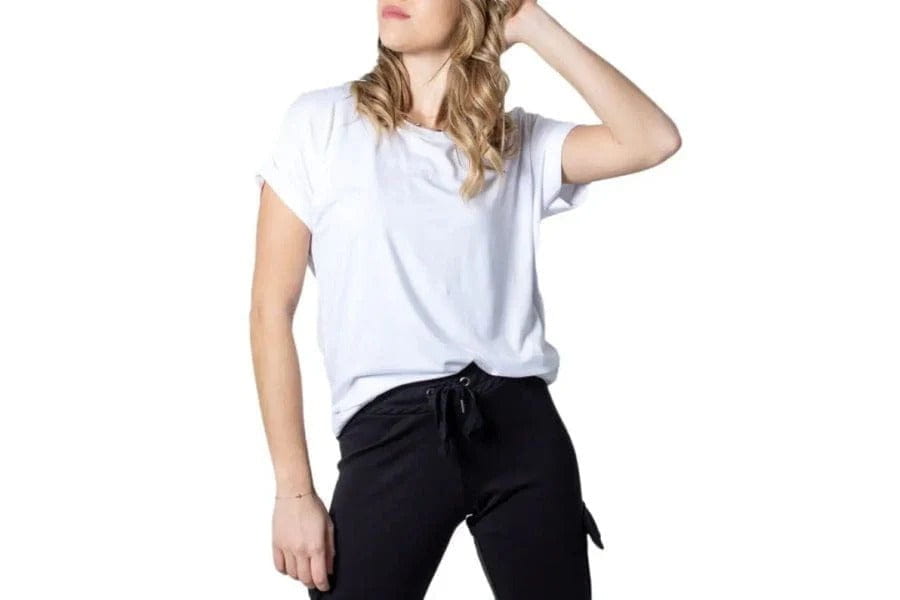 White short-sleeve cotton t-shirt styled with black pants for a trendy look.