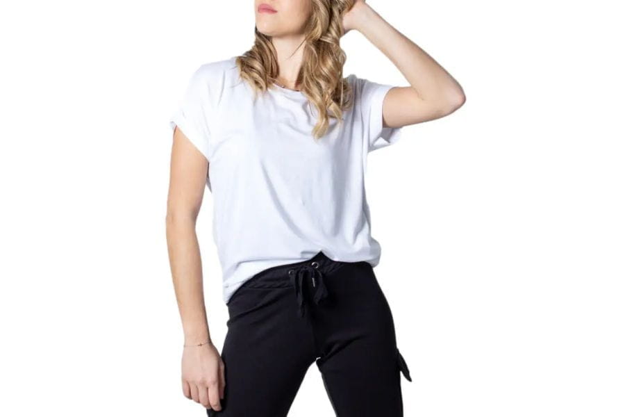 White t-shirt worn by a person with long blonde hair for summer work outfits.