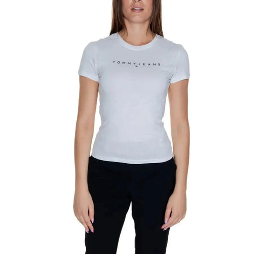 Woman wearing White Tommy Jeans T-shirt and dark pants from Tommy Hilfiger Jeans collection