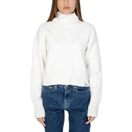 Calvin Klein white turtleneck sweater paired with blue jeans for women knitwear collection