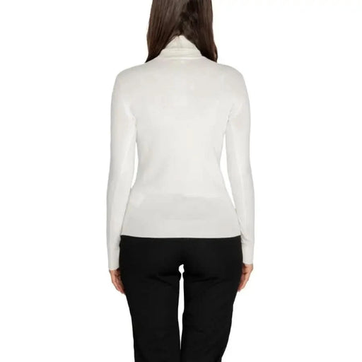 White turtleneck sweater worn by a model with long dark hair from Guess Women Knitwear