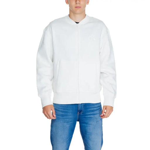 Calvin Klein Jeans Men White Zip-up Bomber Jacket over Blue Jeans - Stylish Menswear Ensemble