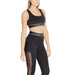 Woman in black Calvin Klein athletic crop top and leggings showcasing sporty style