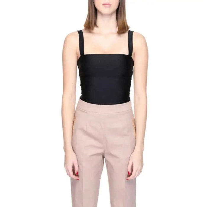 Woman in urban city style wearing Silence black top and beige pants