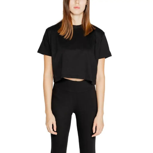 Woman in black cropped t-shirt and high-waisted pants from Icon Women T-Shirt