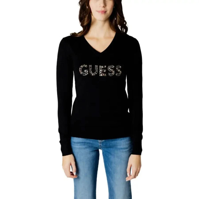 Woman in Guess Women Knitwear black sweater with gold SEI logo