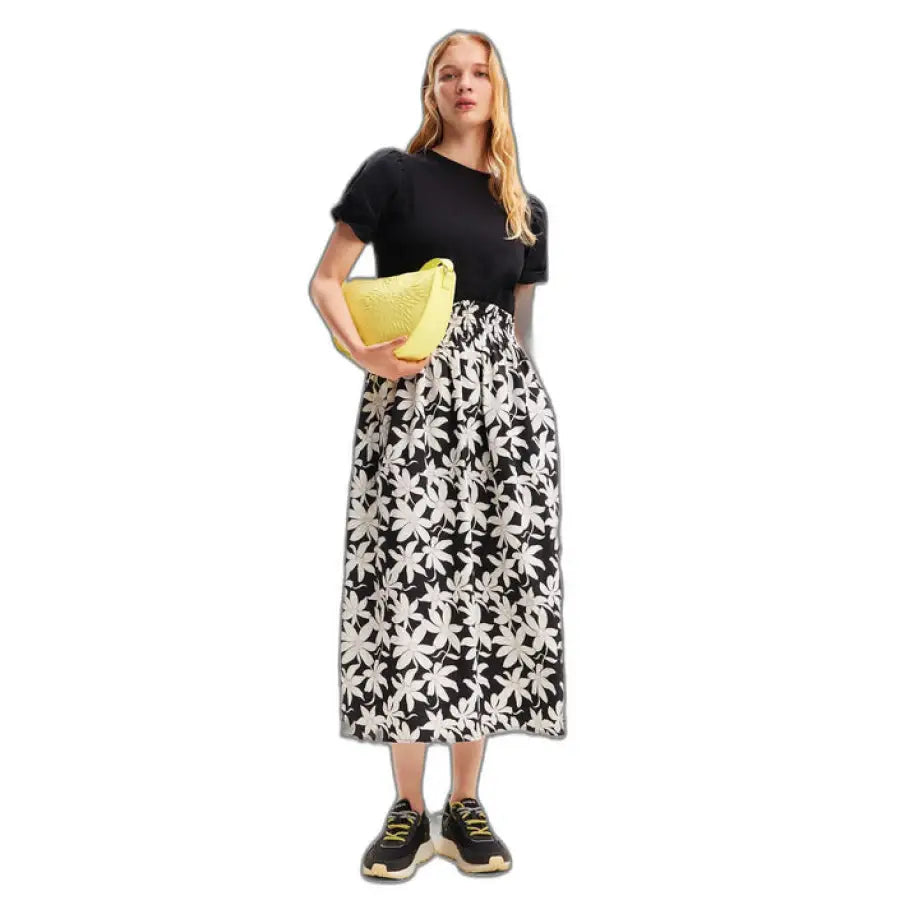 
                      
                        A woman in a black and white Desigual dress showcasing urban style clothing
                      
                    