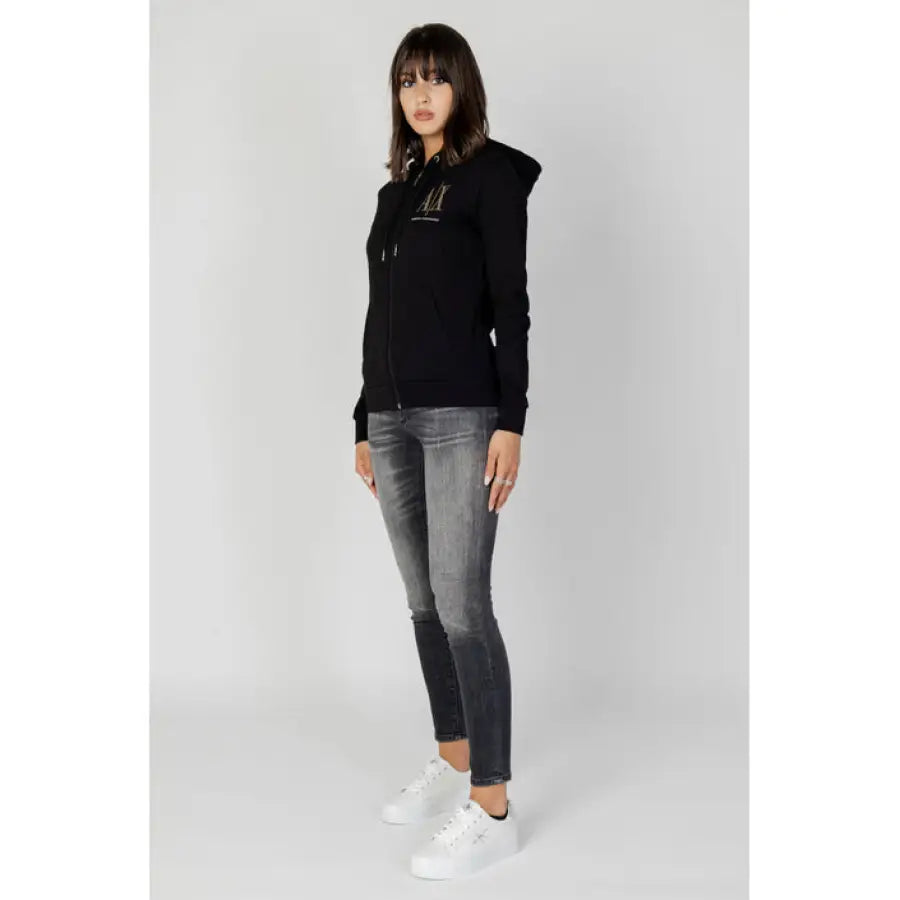 
                      
                        Woman in Armani Exchange black zip-up hoodie, gray jeans, white sneakers
                      
                    