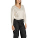 Woman in a cream V-neck sweater and black trousers from Vero Moda Knitwear